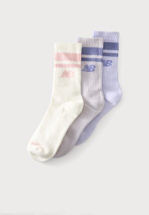 Trois chaussettes montantes côtelées en blanc, gris clair et violet clair, chacune avec des rayures horizontales et un logo New Balance sur le bord-côte.