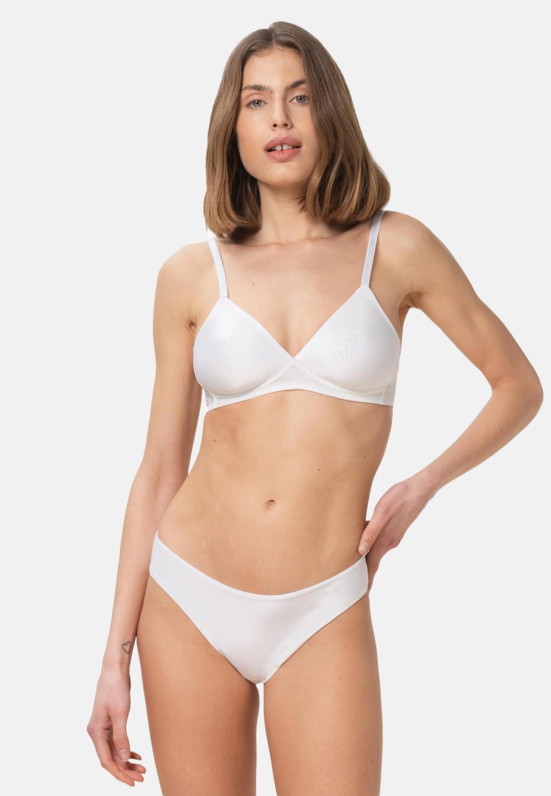 Conjunto de lencería blanca que incluye un sostén suave y elástico con copas triangulares y tirantes ajustables delgados, acompañado de bragas a juego de cintura baja.