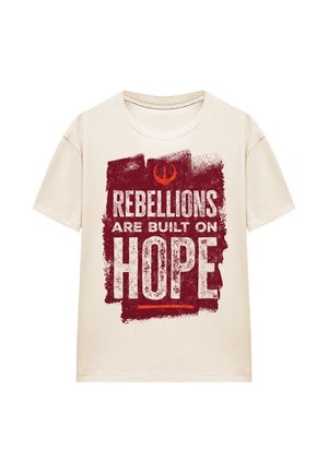 Cremfarbener T-Shirt mit einem grafischen Design in Rot und dem Text "REBELLIONS ARE BUILT ON HOPE" auf einem strukturierten Hintergrund. Kurzarm.