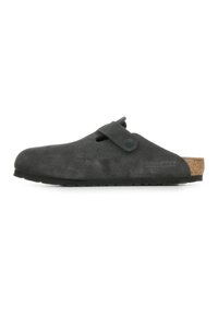 Chaussure noire en suede à enfiler avec une semelle en liège, présentant une sangle latérale, un bout arrondi et une semelle en caoutchouc texturée.