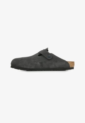 Chaussure noire en suede à enfiler avec une semelle en liège, présentant une sangle latérale, un bout arrondi et une semelle en caoutchouc texturée.