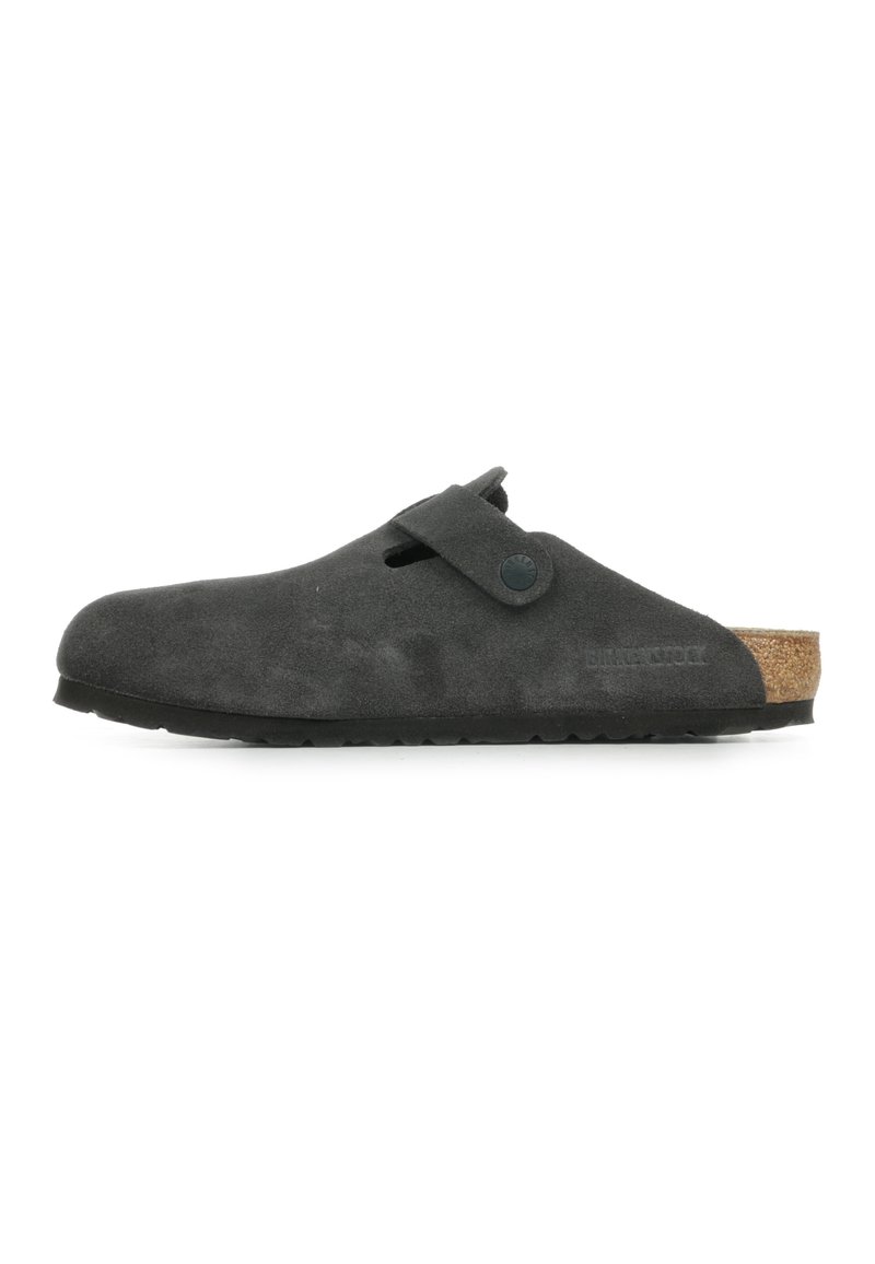 Chaussure noire en suede à enfiler avec une semelle en liège, présentant une sangle latérale, un bout arrondi et une semelle en caoutchouc texturée.