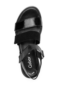 Schwarze Sandalen mit zwei glänzenden und einem Wildlederriemen, offenes Design, gepolsterte Fußbett und eine Schnallenverschlus am Knöchel.