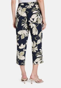 Niebieskie, krótkie spodnie w kwiatowy wzór w kolorze kremowym i oliwkowym. Miękka tkanina oraz elastyczny pasek w talii dla wygody. Idealne na codzienne noszenie.