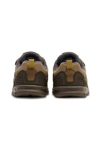 Bruna sportskor med en texturerad ovandel, vadderad krage och perforerade detaljer. Gummisula, kontrasterande beige accenter och dragrem.