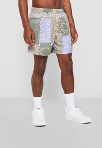 Pantaloni scurți de înot cu un design patchwork din bandană în nuanțe de verde, albastru și bej, având un talie elastică și un șnur de contrasting portocaliu.