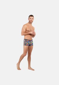 Mans badbyxor i ett blått blommönster. Dessa har ett svart midjeband och en färgstark blommig design som visar upp livliga färger och en tät passform.