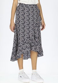 Marineblumige Midirock mit Rüschensaum, versehen mit kleinen weißen und rosa Blumen, aus leichtem Stoff gefertigt, kombiniert mit weißen Sneakers.