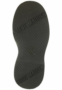 Suola di scarpa in gomma nera con scanalature diagonali e "STEVE MADDEN" impresso due volte sulla suola.