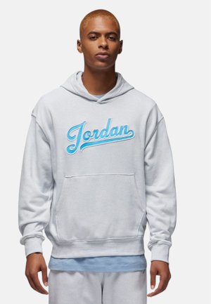 Lys grå hoodie med en frontlomme, der har et blåt broderet "Jordan" logo. Blødt stof, afslappet pasform og snoretræk ved hætten.