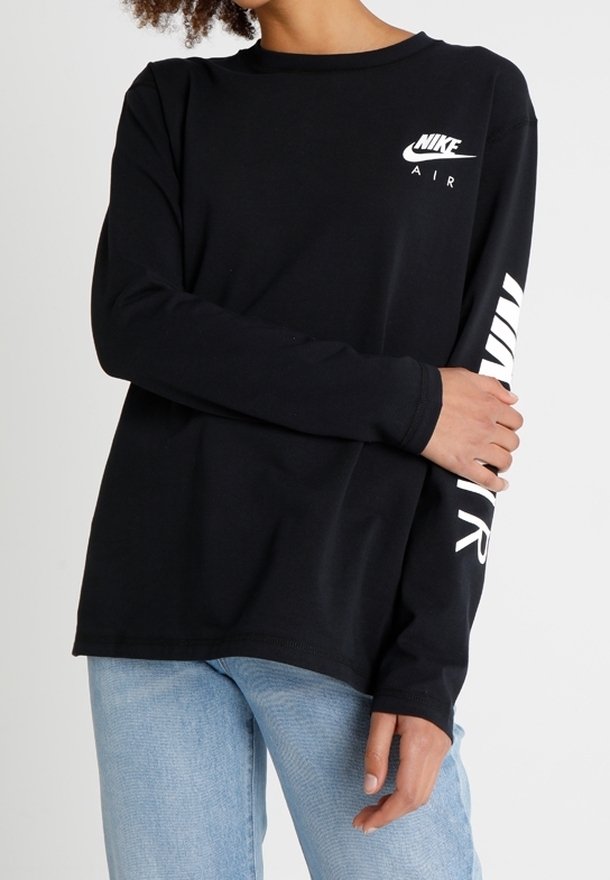 Svart långärmad Nike t-shirt med vitt tryck på bröstet och ärmen, tillverkad i bomull med rund halsringning och avslappnad passform.