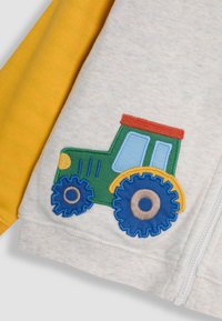 Grauer Pullover mit gelben Ärmeln, der auf der Vorderseite ein buntes, gesticktes Traktor-Design in grün, blau, rot und gelb zeigt.