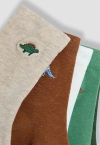 Cuatro pares de calcetines de tripulación: beige con bordado de dinosaurio verde, marrón, blanco y verde con varios diseños de dinosaurios. Material de mezcla de algodón.