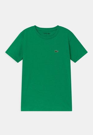 Groen T-shirt met korte mouwen en ronde hals, met klein geborduurd krokodillenlogo op de linkerborst, plat liggend op neutrale achtergrond.