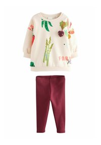Bluza z kolorowymi nadrukami warzyw na kremowym tle, z prążkowanymi mankietami, połączona z bordowymi legginsami bawełnianymi.