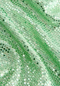Tissu en sequins verts avec une texture scintillante, comportant des sequins ronds réfléchissants de tailles variées sur une base en tissu tissée.
