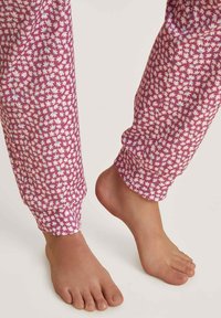 Floral print pyjamabroek in tinten van roze en blauw, met een elastische boor aan de enkels. Het ontwerp bevat kleine bladerenpatronen.