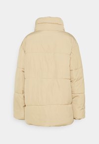 Beige péřová bunda s vysokým límcem, prošívanou strukturou a elastickými manžetami, s volným střihem a bez viditelných zapínání na zádech.