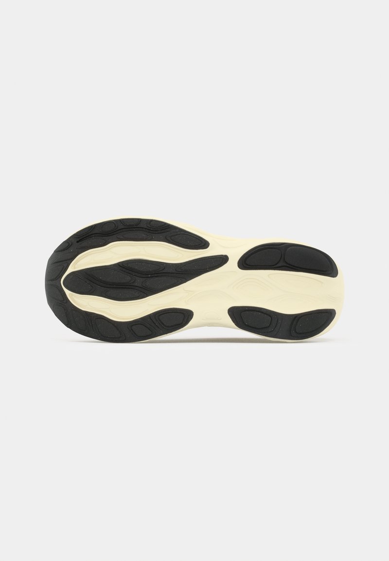 Suela de zapato con patrones de tracción negros sobre una base beige, mostrada contra un fondo gris claro liso.
