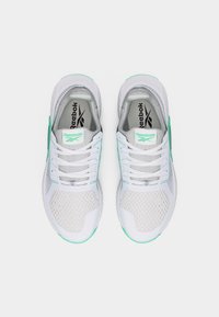 Λευκά και μέντας πράσινα αθλητικά παπούτσια Reebok με πλέγμα στο πάνω μέρος, κορδόνια και λογότυπο στη γλώσσα, εμφανιζόμενα από πάνω σε λευκό φόντο.