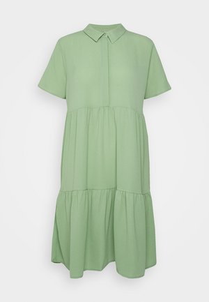 Robe vert clair à manches courtes à volants avec col chemise et patte de boutonnage sur fond uni.