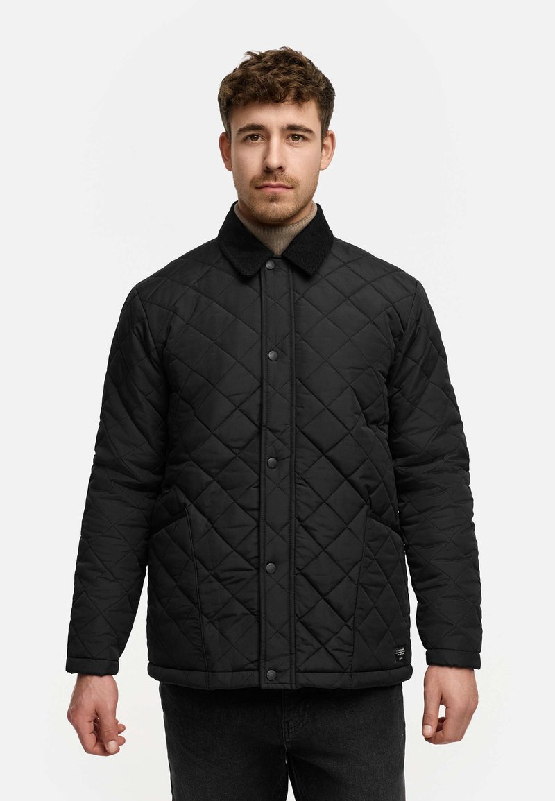 Chaqueta de quilt negro con cuello de pana, cierres de botón en la parte delantera, dos bolsillos laterales y tejido texturizado.