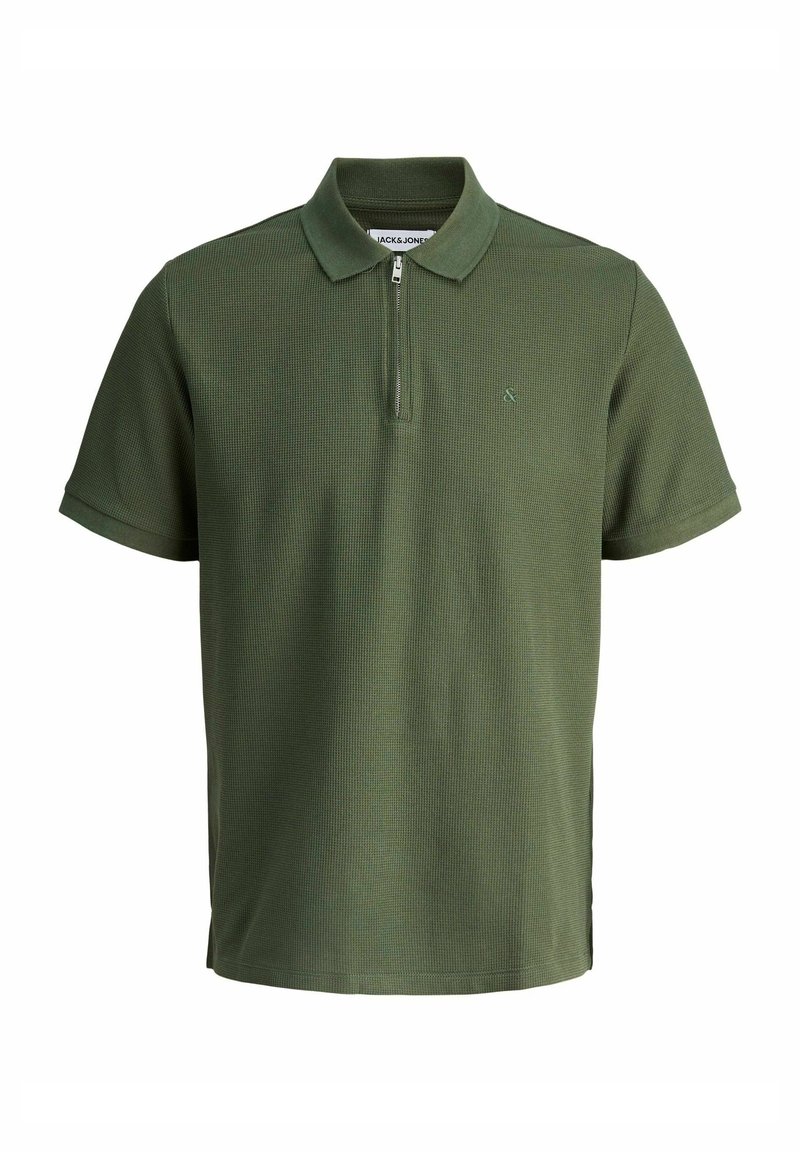 Žalias polo marškinėliai su tekstūruotu raštu, trumpomis rankovėmis, užtrauktuku ant apykaklės ir maža logotipo etikete krūtinėje. Pagaminta iš kvėpuojančios medžiagos.