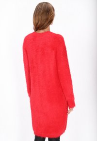 Roter, fuzzy, langärmeliger Pullover mit lockerer Passform, aus texturiertem, flauschigem Material und mit abgerundetem Saum für eine entspannte Silhouette.