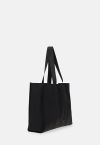 Sort tote bag lavet af slidstærkt stof, med to brede stropper, rektangulær form og en struktureret frontpanel med et subtilt logo-mærke.