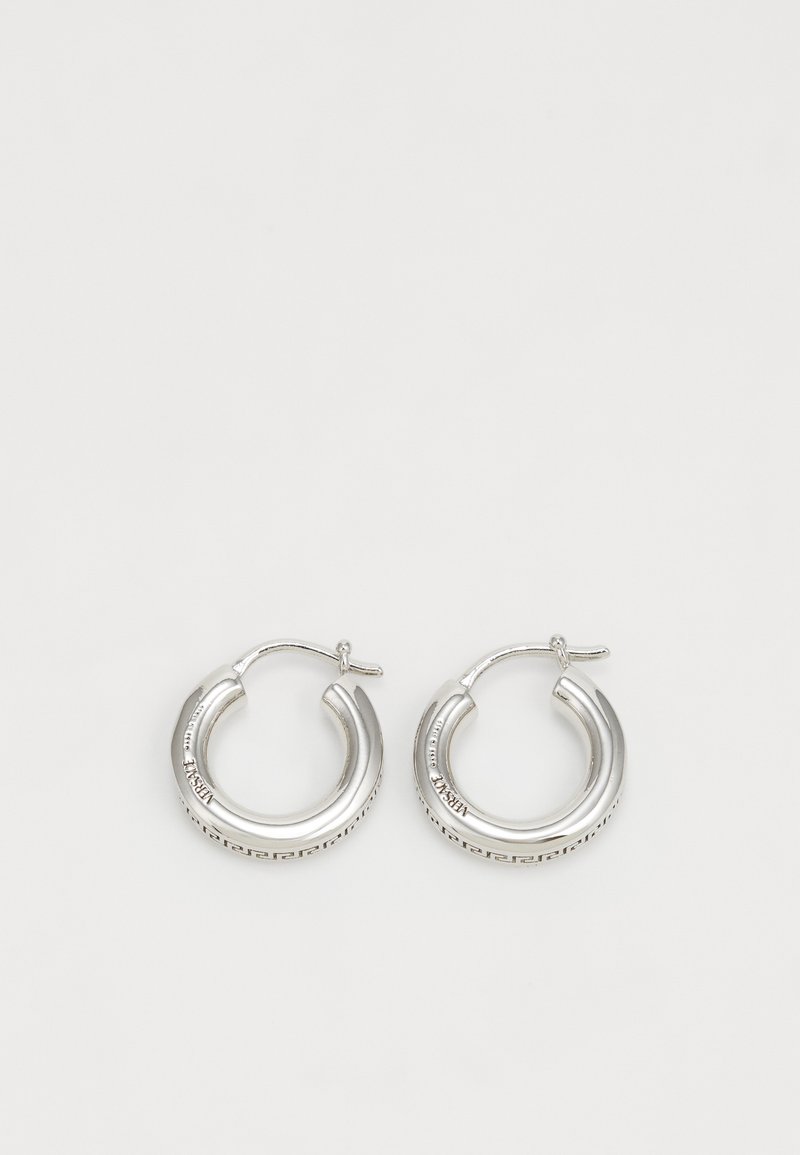 Ασημένια σκουλαρίκια κρίκοι με γυαλιστερό φινίρισμα, που διαθέτουν ένα λεπτό γεωμετρικό μοτίβο κατά μήκος της κάτω άκρης και με κλείσιμο τύπου πείρου.
