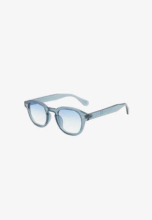 Occhiali da sole azzurri chiari con lenti rotonde, montatura in plastica trasparente e bracci leggermente curve. Lenti con gradiente che va da chiaro a trasparente.