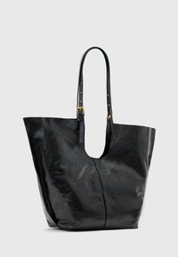 Borsa a tracolla nera in pelle con spallacci regolabili e fibbie color oro, esposta su uno sfondo chiaro e semplice.