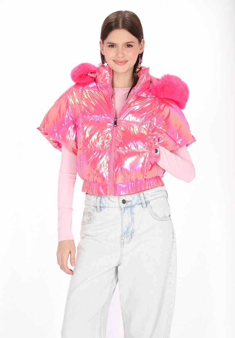 Pufi, rövidített dzseki irizáló rózsaszín anyagból, szőrmével díszített vállrésszel, elöl cipzárral és elasztikus szegéllyel. Világos farmernadrággal viselve.