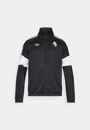 Czarna sportowa kurtka z wysokim kołnierzem, białymi rękawami, różowymi haftowanymi logo i kontrastującym różowym wzorem. Lekka tkanina, zapięcie na zamek.