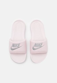 Des claquettes rose clair avec une large sangle en caoutchouc arborant un logo Nike argenté. Semelle intérieure texturée pour une bonne adhérence et un confort optimal. Design ouvert à l'avant avec un bout arrondi.