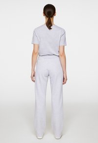 Grijze katoenen t-shirt en brede sweatpants, met een ontspannen pasvorm en elastische tailleband, met een gladde textuur en minimale naden.