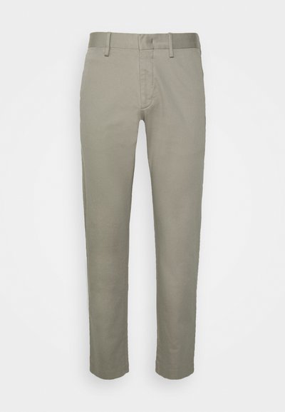 Jasnoszare spodnie khaki o slim fit, z płaskim przodem, standardowymi kieszeniami i gładką teksturą materiału.