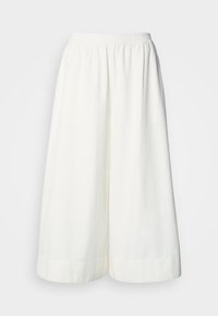 Λευκό παντελόνι φαρδύ και κομμένο στο ύψος των αστραγάλων με ελαστική μέση και άνετη εφαρμογή, παρουσιασμένο σε απλό φόντο.