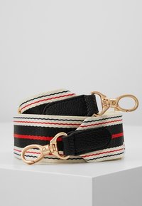 Cinturino intrecciato in crema, nero e rosso con un motivo a strisce. Presenta clip in metallo tono oro e dettagli in pelle nei punti di attacco.