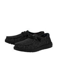 Zapatos de tela negros con parte superior texturizada, cordones y una suela acolchada. El interior cuenta con un forro estampado.