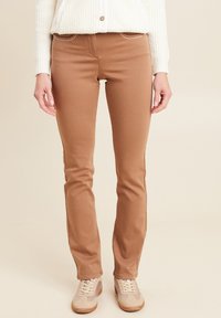 Pantaloni in misto cotone marroni con un design aderente, cuciture decorative lungo le tasche e una leggera elasticità per il comfort.