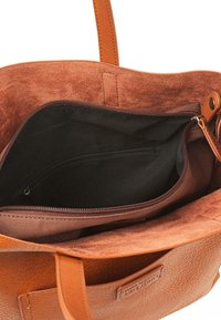 Bolsa tote de cuero marrón con un interior suave, que incluye un bolsillo con cremallera y una textura parecida al ante en el interior. Diseño de apertura superior para un fácil acceso.