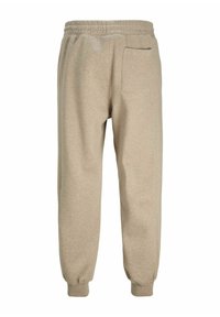 Beige sweatpants lavet af blødt stof, med elastisk talje, tapered ankler og en enkelt baglomme.
