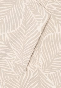 Beige stof met een subtiel palmblaadjespatroon, met lichte en donkere tinten, een gladde textuur en omgevouwen randen.