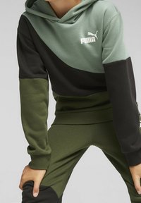 Groene, zwarte en donkergroene color-block hoodie met een witte Puma-logo. Zachte stof met ribgebreide manchetten en zoom.