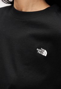 Μαύρο φούτερ από βαμβάκι, με στρογγυλή λαιμόκοψη και λευκό κεντητό λογότυπο στο αριστερό στήθος. Λείο ύφασμα, casual σχεδίαση.