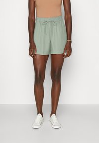 Light green shorts with an elastic waistband and drawstring. Made from a textured fabric, featuring a relaxed fit and pockets.