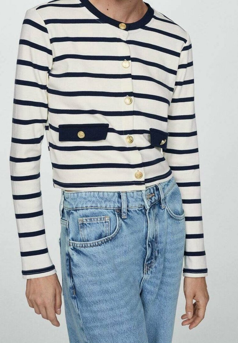 Cardigan court rayé bleu marine et blanc avec manches longues, boutons dorés et deux poches bleu marine, associé à un jean en denim bleu clair.