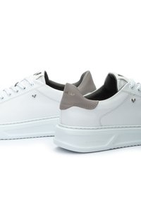 Sneakers bianchi in pelle con accenti grigi, design a punta rotonda, lacci tono su tono e colletto imbottito. Dettaglio del logo sul lato e sul tallone. Suola in gomma.