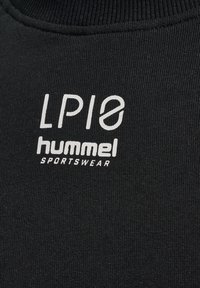 Svart sporttyg med vit text "LP18 hummel SPORTSWEAR" tryckt på bröstområdet.